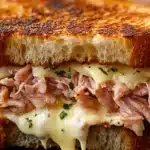 What is a Georgia Reuben Sandwich? 11 grilled-ham-and-cheese-sandwich-toasted-bread-melted-cheese-and-shredded-ham-filling-garnished-with-herbs